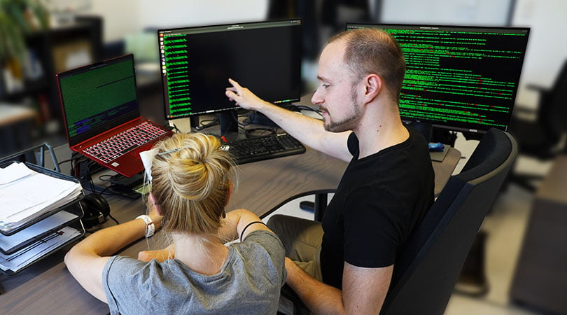 Two scientists looking at a screen which display data for Bioinformatics services